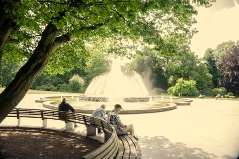 Pensioners in a spa park in front of a fountain Stock Photos