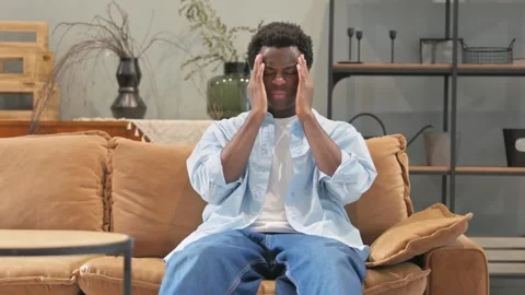 Pensive African Man Brainstorming while Sitting at Home Stockbeeldmateriaal 299760779