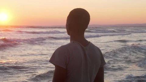 Pensive african man looking the sunset on the beach. Migration,missing Africa Vidéo 96318007