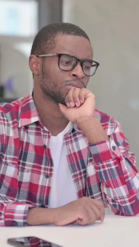 Pensive African Man Thinking While Sitting in Office, Vertical Video Stock Footage 340040538