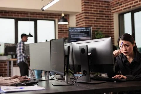 Pensive asian tech enginner working on code development Stock Photos