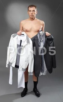 Pensive bachelor holding sports clothing and suit Stock Photos