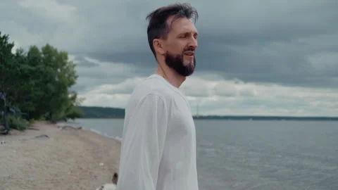 Pensive Bearded Man on Cloudy Seashore Stock Footage 328559335