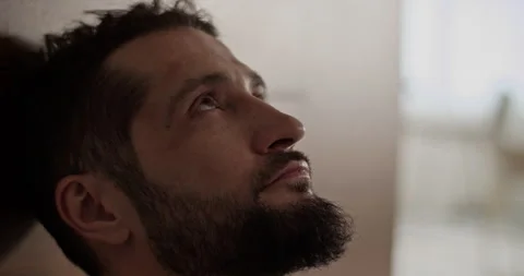 Pensive bearded man looking up against blurred background Stock Footage 271159079