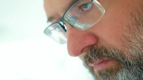 Pensive bearded man looking down with troubled expression, lost in thoughts and Stock Footage 346285382