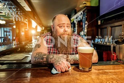 Pensive bearded man standing in tap-room Stock Photos