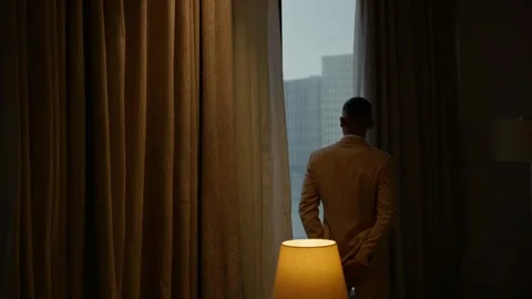 Pensive Black Man in Suit Looking Out Hotel Window Stock Footage 306280027