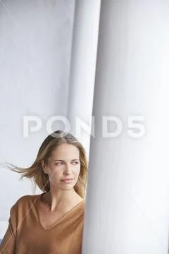 Pensive blonde woman looking away on patio Stock Photos