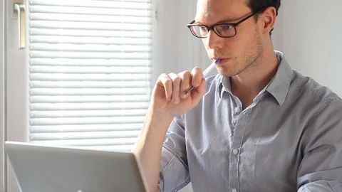 Pensive business man working on computer in office Stock Footage 98100645