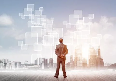 Pensive businessman looking at user interface against modern city background 스톡 사진