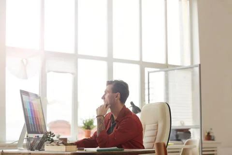Pensive Businessman Using Computer against Window 写真素材