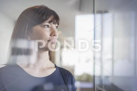 Pensive businesswoman looking out window Stock Photos