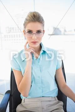 Pensive businesswoman wearing glasses posing Stock Photos