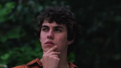 Pensive confused guy leaning hand, rubbing beard while thinking over difficult Stock Footage 243677158