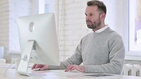 Pensive Creative Man Thinking and Working on Desktop Video stock 121427151