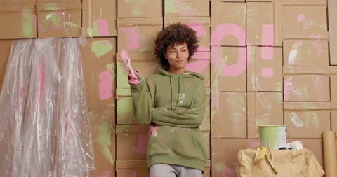 Pensive dark skinned Afro American woman plans redecoration of room chooses Stock Footage 144922826