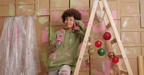 Pensive dark skinned Afro American woman thinks about paint of new home holds Stock Footage 145350156