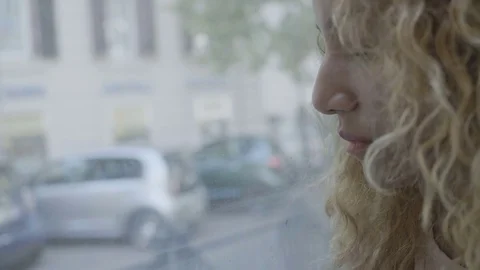 Pensive depressed woman sitting alone near the window of a bus in the city Stock Footage