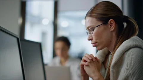 Pensive developer analyzing software closeup. Thoughtful woman looking computer Stock Photos