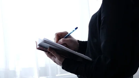 Pensive female student makes notes in a notebook or diary. slow motion Stock Footage 88458877