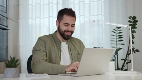 Pensive freelancer typing on laptop while sitting at table in personal cabinet Stock-Footage 262292766