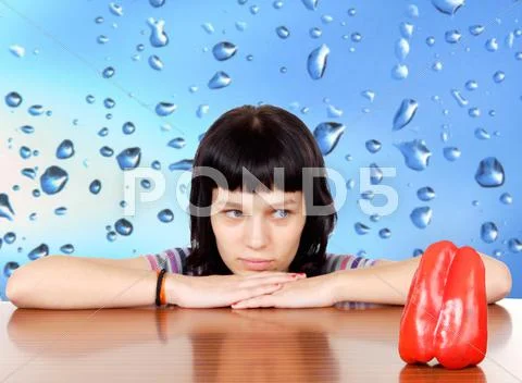 Pensive girl lookin a red pepper Stock Photos
