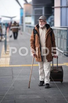 Pensive gray-haired male is going with luggage Stock Photos