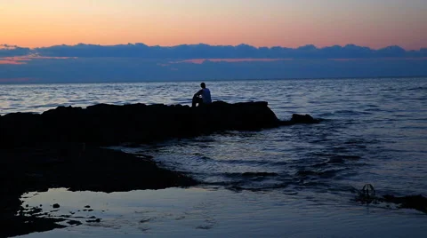 Pensive Guy on Rocks Sihouette Stock Footage 57729989