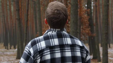 A pensive guy stands in the forest. Colorful winter forest Stock Footage 146276409