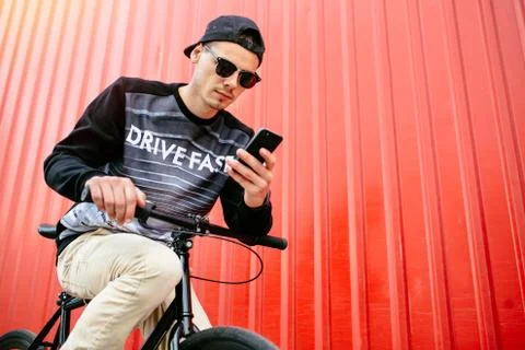 Pensive guy using a smartphone while sitting on the bike Stock Photos