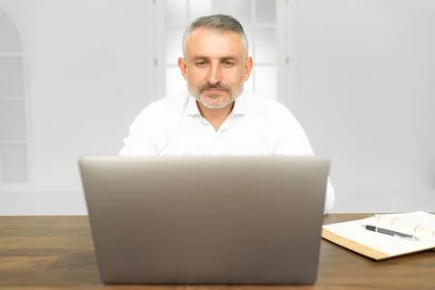 Pensive it professional reading text information from website on laptop device Stock Photos