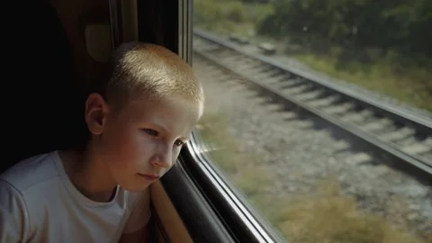 Pensive kid leaned his head against the window. Boy is traveling by train. Stock-Footage 149240795