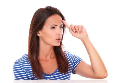 Pensive lady looking to her left and pointing to her forehead in white backgr Stock Photos