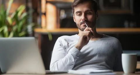 Pensive male thinking over problem solution working on laptop Foto stock