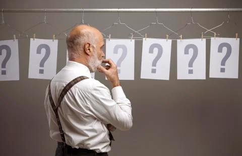 Pensive man comparing different possibilities and questions Stock Photos