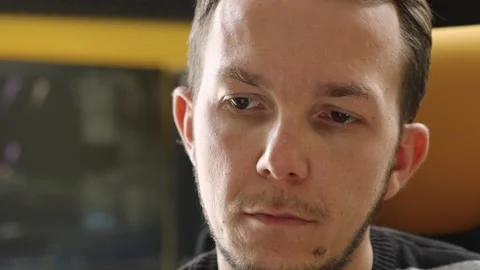 Pensive man concentrating in front of documentation in tech-themed modern office Stock Footage 309322020