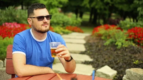 Pensive man is drinking beer in the park Stock Footage 65814603