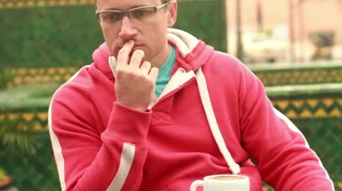 Pensive man drinking coffee in cafe by city street, outdoors, steadicam shot Stock Footage 10854315