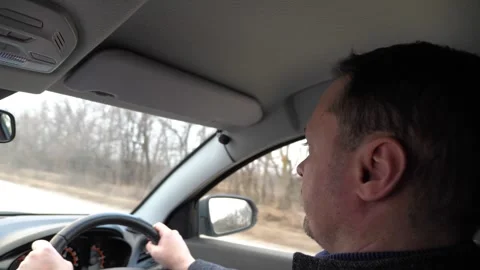 Pensive man driver riding car with hands on steering wheel back side view Stock Footage 281461493