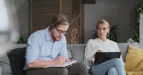 Pensive man freelancer in headset noting information planning project remotely Stock Footage 165876682