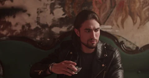 Pensive man having refreshment sitting on couch at home Video stock 260561293