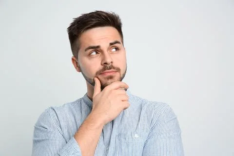 Pensive man on light background. Thinking about answer for question Stock Photos