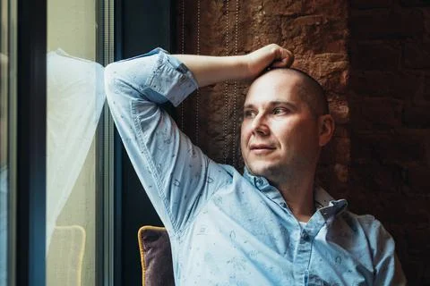 Pensive man looking out the window. Stock Photos