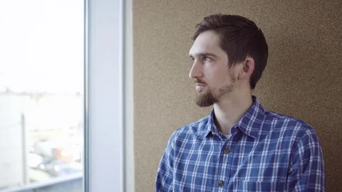 Pensive man looking through the window Stock Footage 74681063