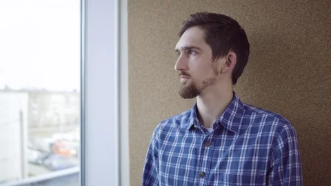Pensive man looking through the window Stock Footage 75163697