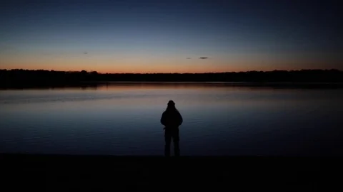 Pensive Man Looks out to Lake During Sunset Stock Footage
