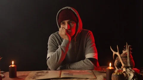 Pensive man propping face with hand at table with candles 스톡 동영상 125838817