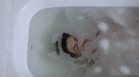 Pensive man reflects his problems immersed in the bath tub - bathtube - dive Stock Footage 24704071