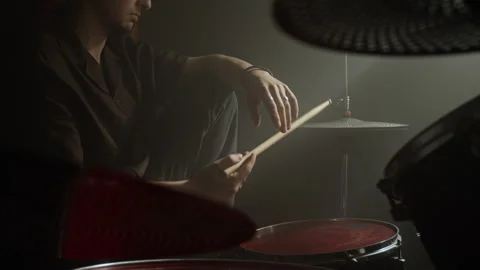 Pensive Man Sitting by Drum Kit Holding Drumsticks in Music Studio Stock Footage 338400410