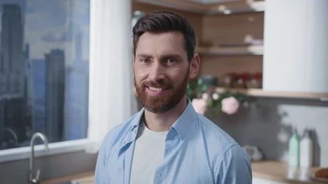 A pensive man is sitting in a modern kitchen, enjoying a scenic view of the city Stock Footage 316038689